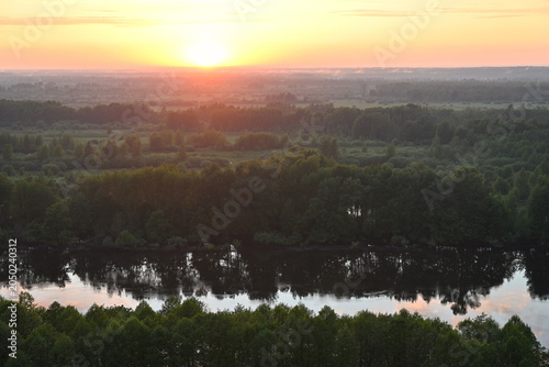 Breathtaking view from a hill with a calm river during sunset