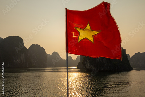 Canvastavla National flag of Vietnam waving on a boat at sunset in Halong Bay with limestone