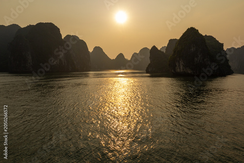 Photography Golden sunset over the sea with silhouette of limestone islands in Halong Bay Vi