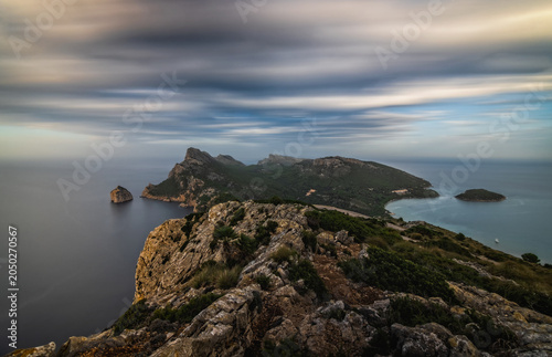 View from the Albercutx Watchtower towards the island Colomer and the mountain range on Formentor peninsula, cloudy sunrise. Mallorca, Spain, October 2024. Long exposure picture