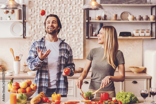 Fotografía A man and woman are in the kitchen preparing food and laughing