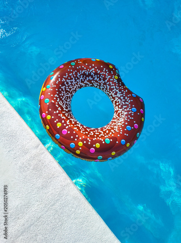 swimming pool ring float in blue water and sky sunlight reflection, holiday and vacation, summer background, top view copy space