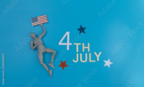 Wooden mannequin holding united states flag celebrating 4th july