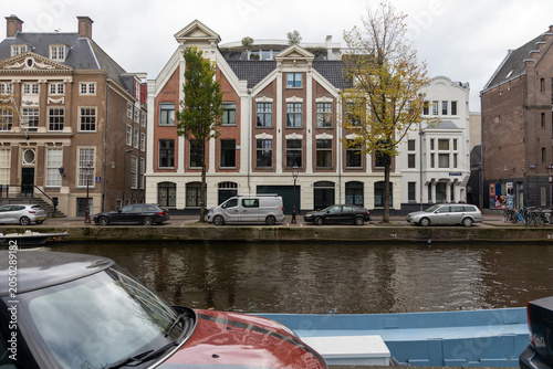 Fotografie Amsterdam urban scene featuring characteristic canal houses lining a historic wa
