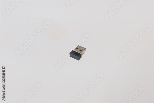 Small black and silver USB wireless dongle receiver for computer mouse on white background