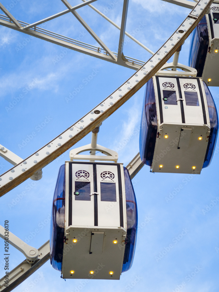 Fototapeta premium Ferris wheel cabins against blue sky