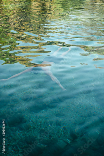 Photos Young man swimming beneath the surface of calm crystal-clear water, capturing pe