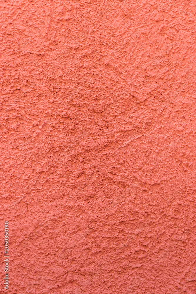 Fototapeta premium Salmon pink rough plaster wall. Architectural seamless pattern of a concrete wall. Textured background.