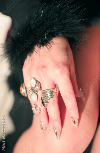 An intimate close-up reveals an array of rings and glamorous fingernails, reflecting personal style and creativity, capturing detailed artistry in a breathtaking visual narrative.