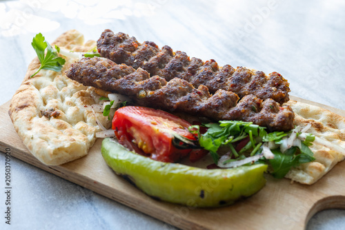 traditional Turkish Adana kebab served with grilled tomatoes and green peppers 