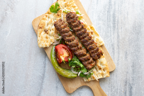 traditional Turkish Adana kebab served with grilled tomatoes and green peppers 