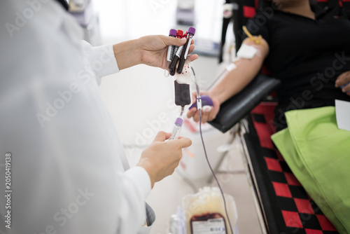 Selective focus hand of doctor blood draw patient into test tube while donating in hospital.Donation for emergency surgery.Save life and medical treatment concept.