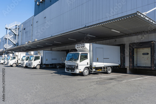 物流倉庫の積み下ろし場に多数のトラックが待機
