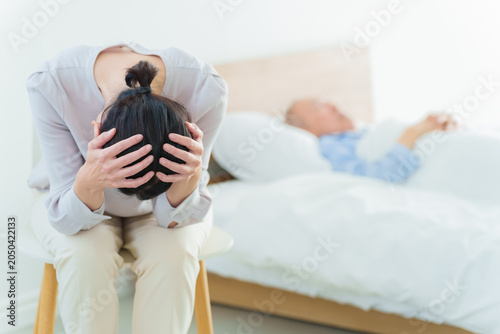 高齢者の介護をする女性　介護疲れ