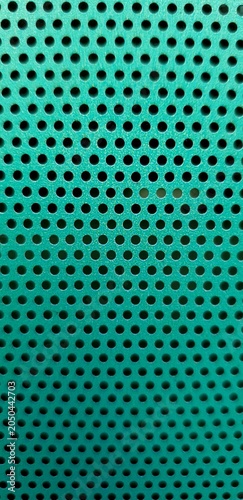 Obraz na płótnie Abstract turquoise perforated metal texture with repeating circular holes, geometric industrial pattern and modern technology background