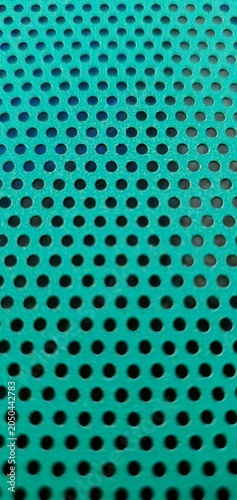 Obraz na płótnie Abstract turquoise perforated metal texture with repeating circular holes, geometric industrial pattern and modern technology background