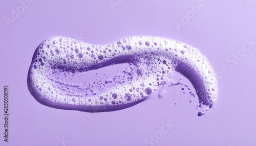 A close-up of a dollop of purple foamy substance on a solid purple background