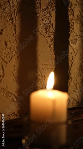 A single lit candle on a table.
