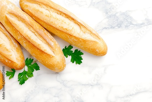 Fresh French baguettes with crisp golden crust and soft inside, garnished with parsley on marble surface