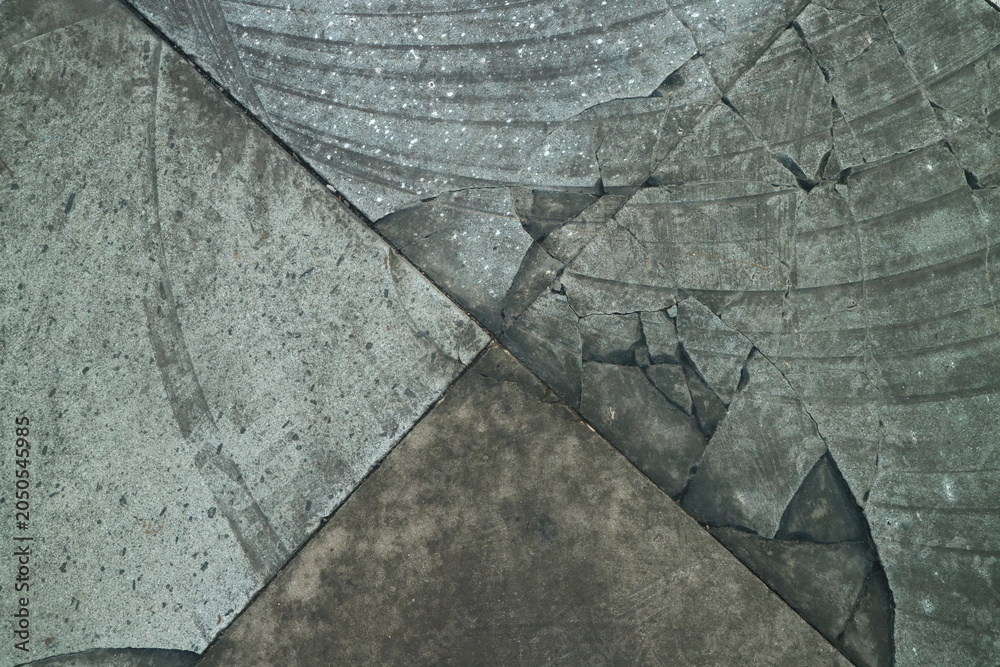 Obraz premium Abstract macro detail of weathered grey stone pavement with geometric cracks and textured mineral surfaces creating a rustic architectural pattern