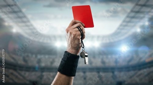 Football referee showing red card during soccer match disciplinary decision