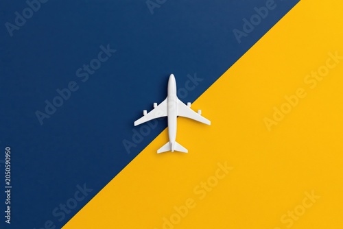 Airplane model plane on split blue and yellow background for travel and aviation tourism
