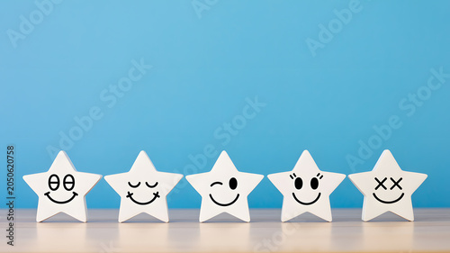 Five white stars with different smiley faces on a blue background