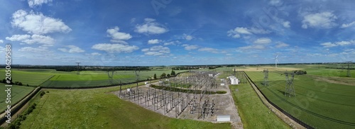 Petite centrale électrique rurale en Meurthe-et-Moselle. Vue aérienne panoramique des installations électriques, transformateurs, pylônes, câbles, répartiteurs. Au milieu des champs et des cultures.