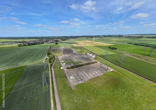 Petite centrale électrique rurale en Meurthe-et-Moselle. Vue aérienne panoramique des installations électriques, transformateurs, pylônes, câbles, répartiteurs. Au milieu des champs et des cultures.