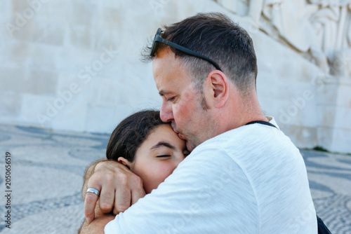 Obraz na plátně Father kissing daughter in an outdoor embrace
