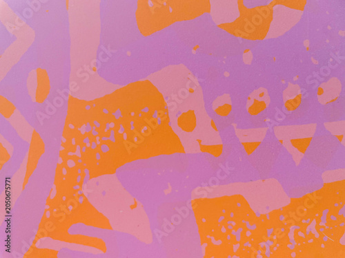 Landscape close up full frame view of a colorful abstract painted pattern with chaotic pink and purple shapes on a bright orange background