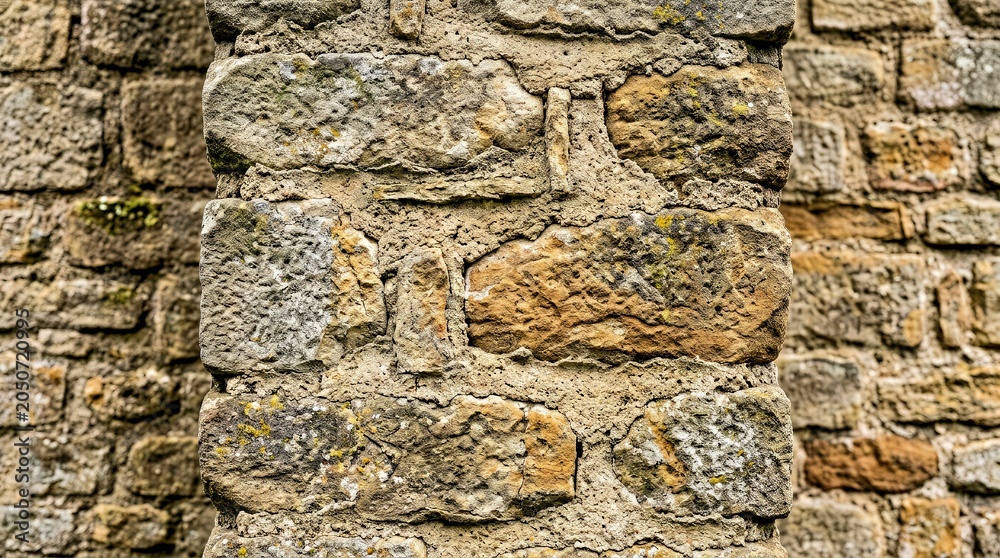Fototapeta premium Close up of Rough Textured Stone Wall With Mortar and Natural Weathering