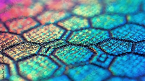 A colorful, iridescent pattern of hexagonal cells with shimmering hues of blue, purple, and green