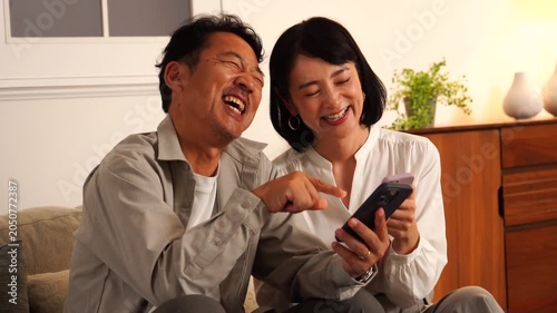 スマホを見て笑い合う熟年夫婦
