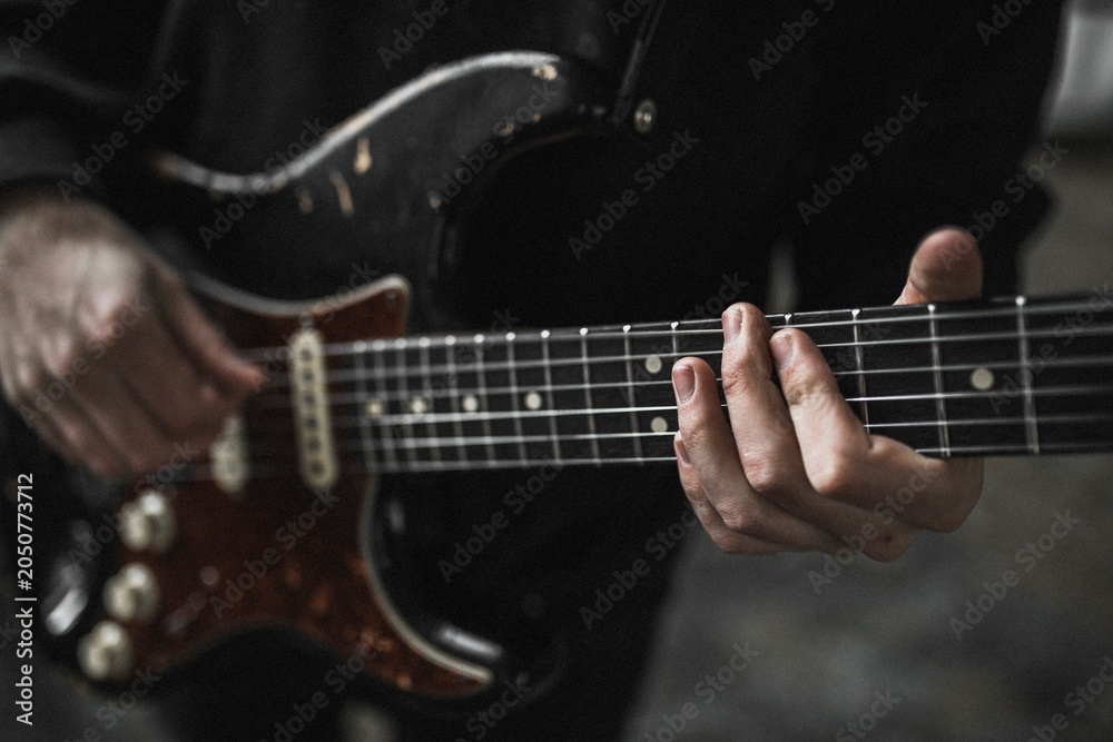 Obraz premium Man playing electric guitar, music performance photo