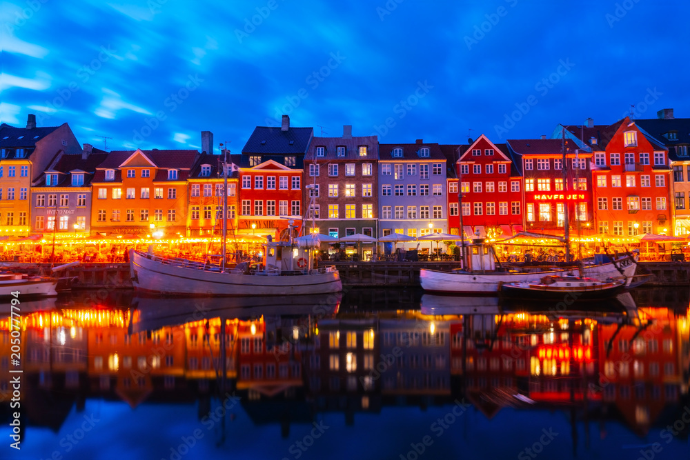Naklejka premium The charm of the Nyhavn Canal: colorful buildings, an iconic place, a tourist destination for strolling and enjoying the view of colorful reflections in the water at night.