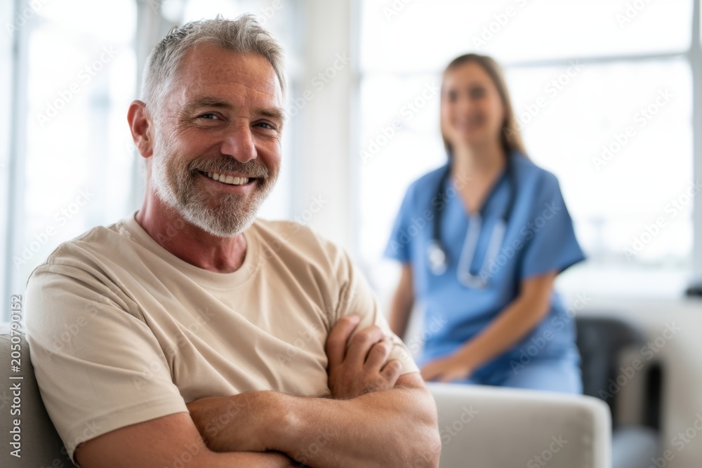 Fototapeta premium The senior man smiling during a relaxed medical consultation with a friendly nurse