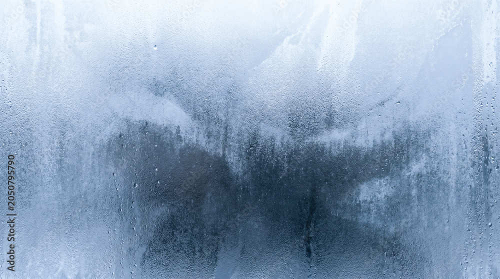Fototapeta premium clear water drops condensation forming upon cold glass window showing beautiful icy blue frosted texture macro abstract wet winter background freezing weather