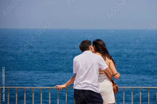 A couple embracing at the coastline of Polignano a Mare, Italy