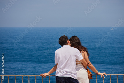 A couple embracing at the coastline of Polignano a Mare, Italy