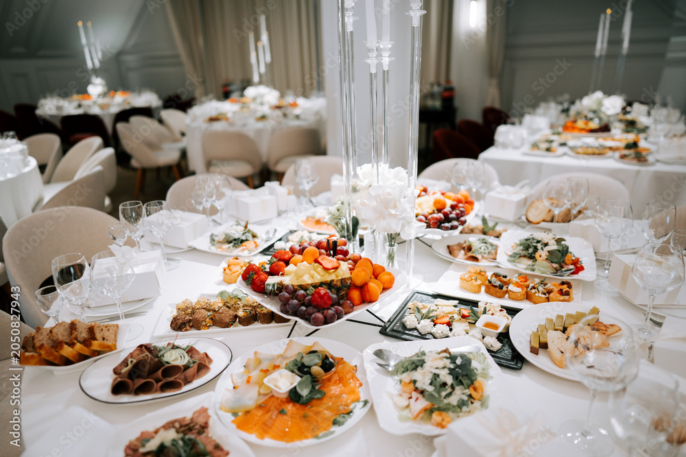 Fototapeta premium Elegant white table spread with diverse dishes for a formal reception
