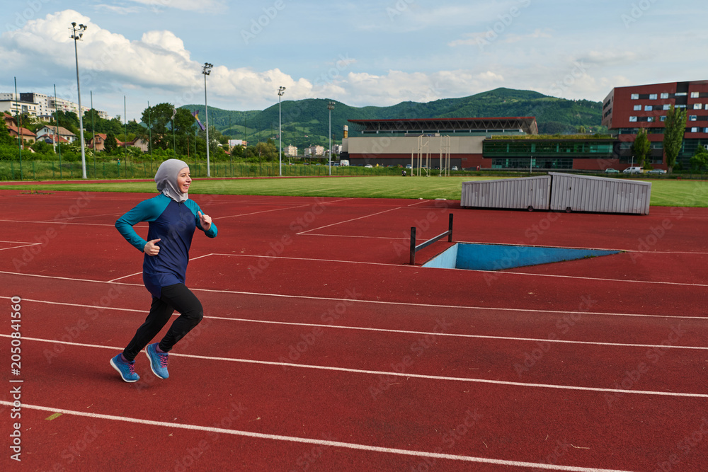 Obraz premium Muslim Woman Running on Outdoor Track in Hijab for Fitness and Healthy Lifestyle Training
