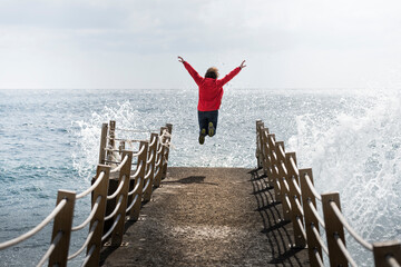 Portugal, Madeira, woman jumping on pier