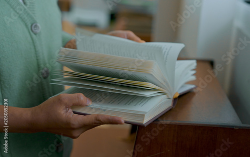 Close-up hand's woman reading book in library.