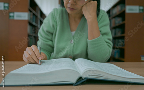 Close-up hand's woman reading book in library.