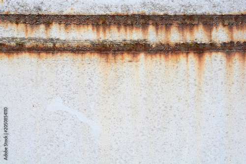 A full frame background texture showing a dirty white painted metal wall with heavy horizontal rust corrosion and brown rust streaks.
