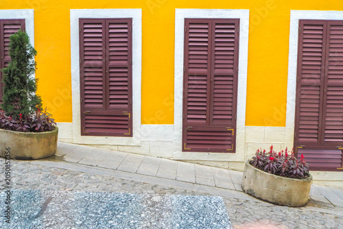 MACAU, CHINA – November 8, 2017: A scenic view of a narrow cobblestone street lined with traditional multi-story residential buildings and vintage green lampposts in the historic district of Macau