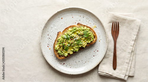 Avocado toast with fresh herbs on white plate minimal breakfast setting