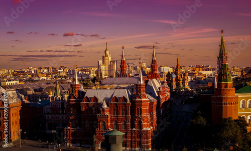 Moscow cityscape with Kremlin towers, State Historical Museum and St. Basil's Cathedral under a dramatic sunset sky, Russia.