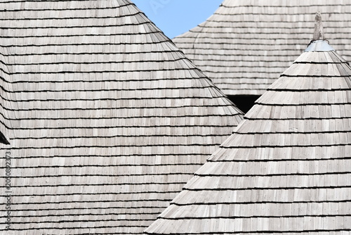 Foto Detailed view of wooden shingle roofs showcasing unique shapes against a clear b